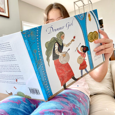 a girl reading Drummer Girl book